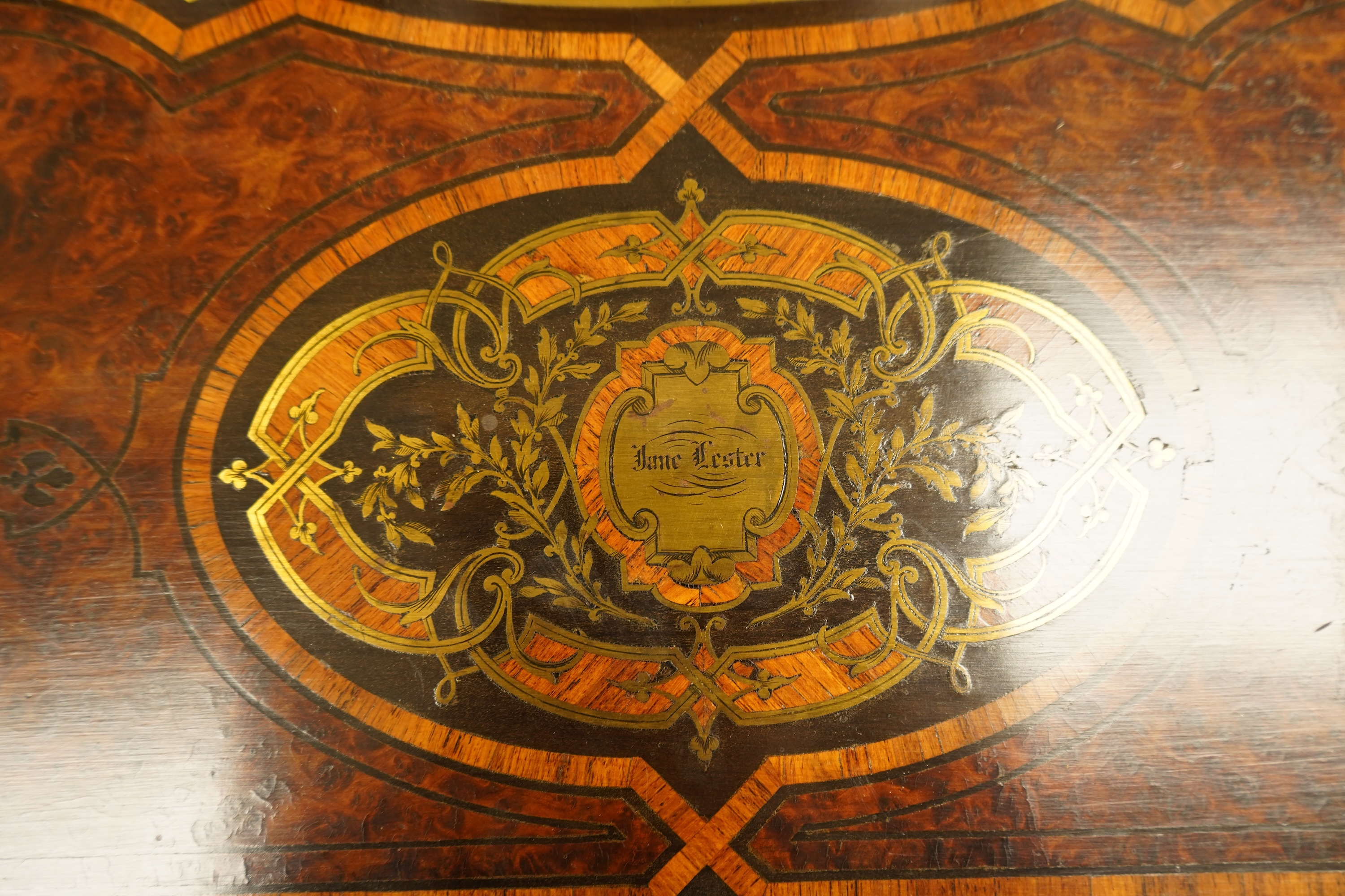 A 19th century French brass inlaid, tulip banded amboyna writing casket, the brass panel inscribed ‘Jane Lester’, 40cm wide